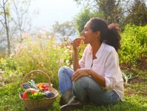 woman eating out of her permaculture garden