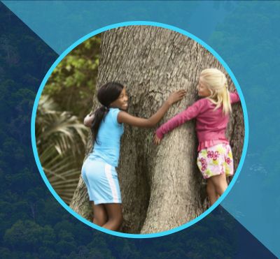 Image of two girls hugging a tree, in front of a faded background of an aerial view of a river running through a forest